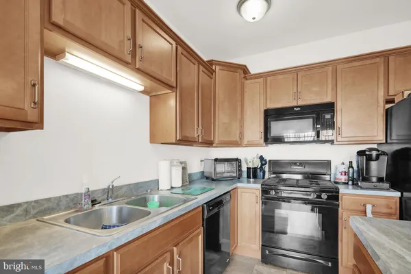 a kitchen with stainless steel appliances granite countertop a sink a stove and a microwave