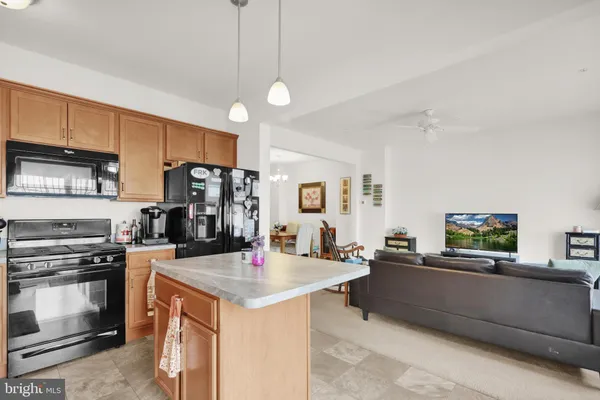 a open kitchen with stainless steel appliances granite countertop a sink a stove and a refrigerator