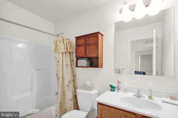 a bathroom with a sink vanity mirror and toilet