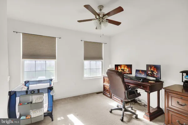 a view of a workspace with furniture and a window