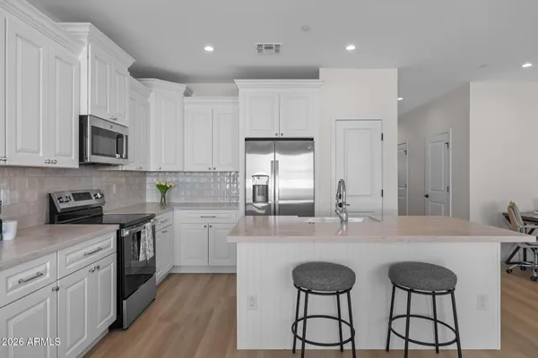a kitchen with kitchen island granite countertop a sink cabinets and stainless steel appliances