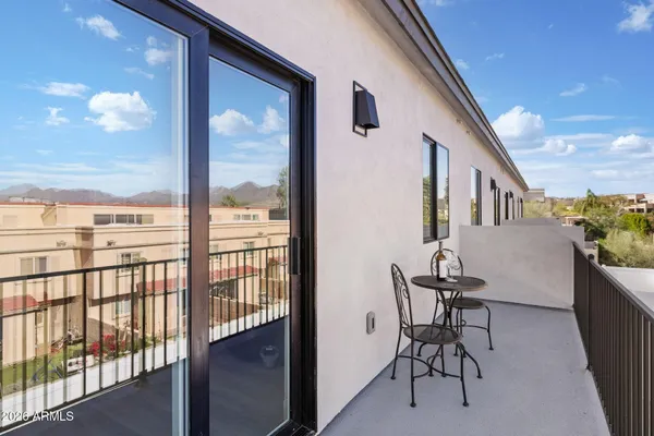 a view of a porch with furniture and floor to ceiling window
