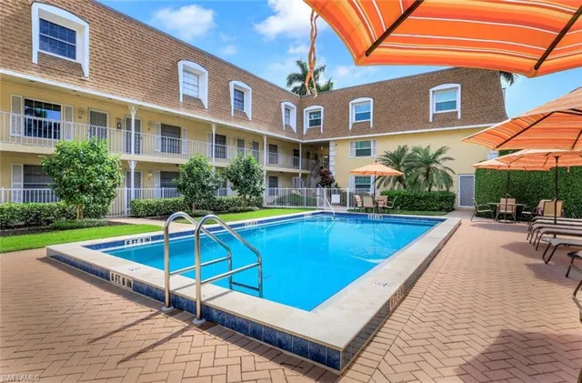 a view of a building with a swimming pool and a yard