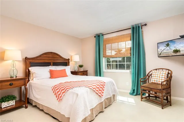 a bedroom with a bed a chair and a large window