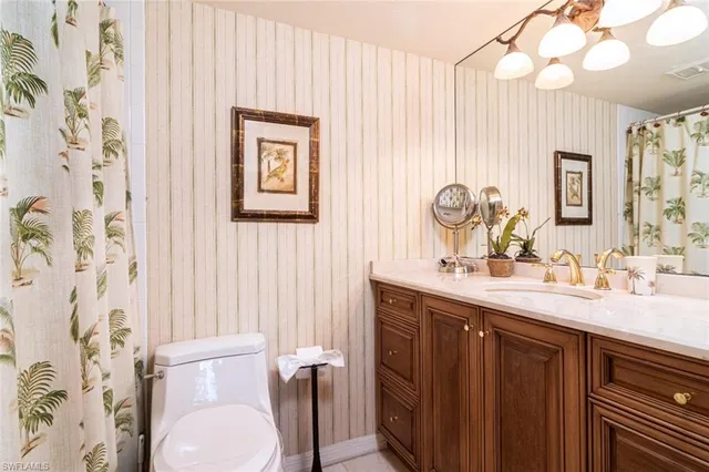 a bathroom with a granite countertop sink mirror vanity and toilet