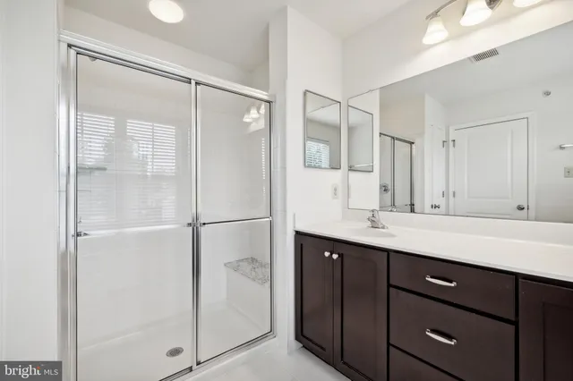 a bathroom with a shower sink and mirror