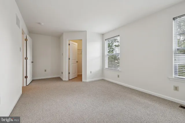 an empty room with windows and closet