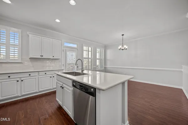 a kitchen with stainless steel appliances a refrigerator sink and wooden floor