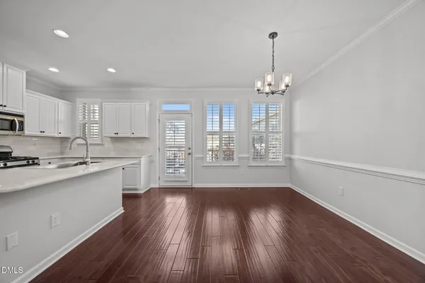 a view of an empty room with wooden floor fireplace and a window