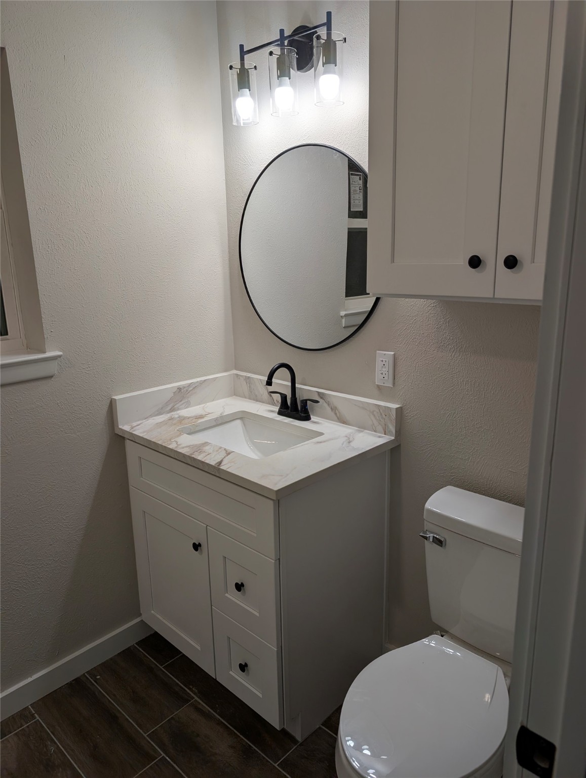 1145 Cuniff Road Sour Lake, TX 77659 - Photo 21 of 22 a bathroom with a granite countertop toilet sink and mirror