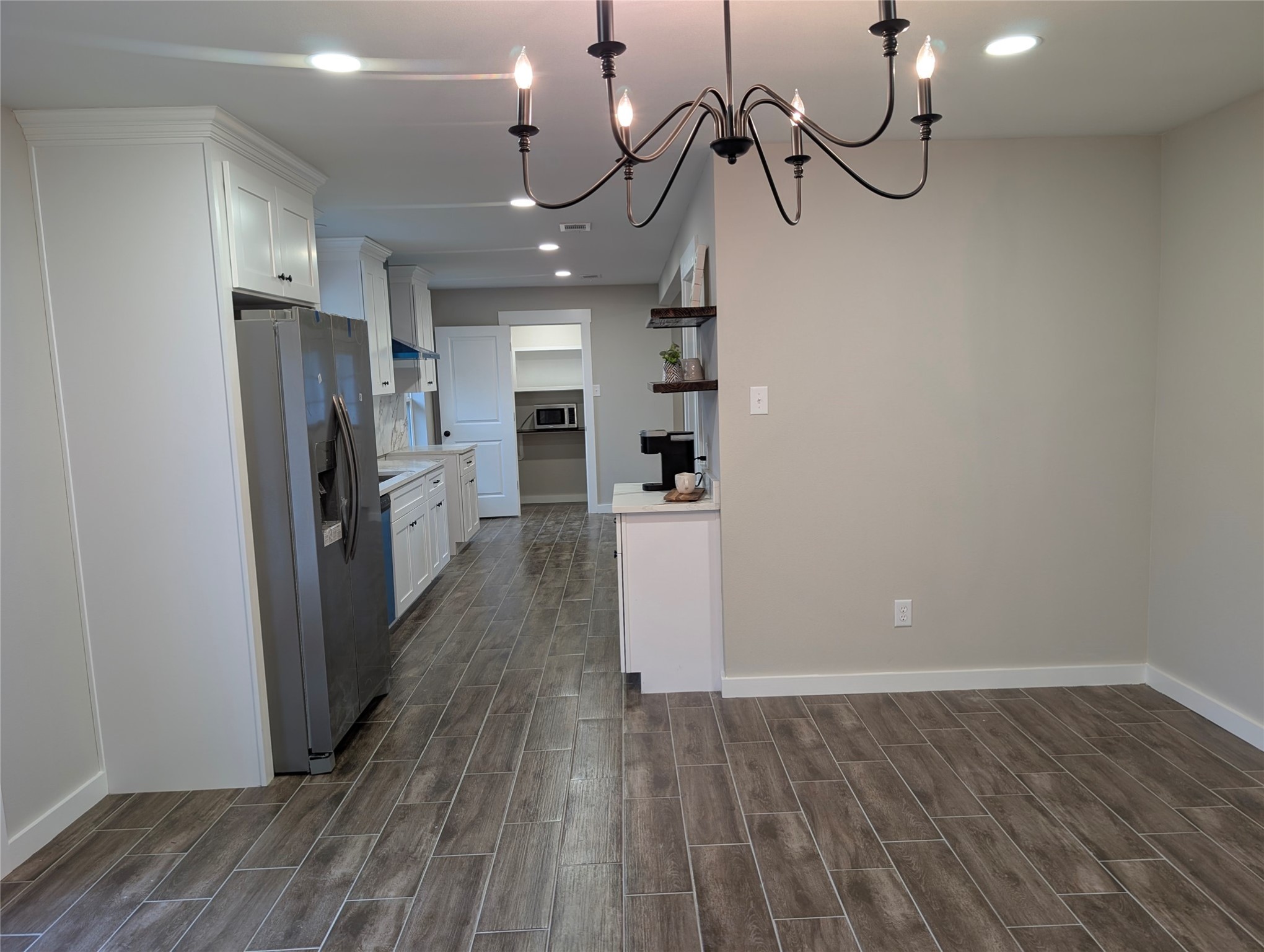 1145 Cuniff Road Sour Lake, TX 77659 - Photo 3 of 22 a view of a kitchen with a refrigerator and a wooden floor