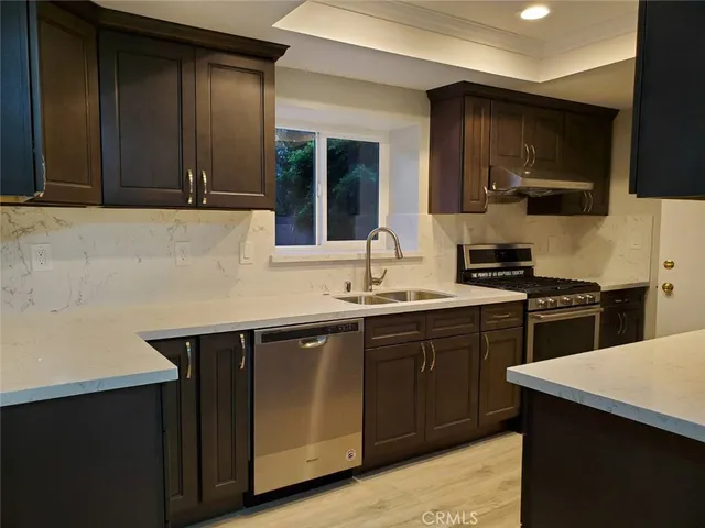 a kitchen with a sink and a stove top oven
