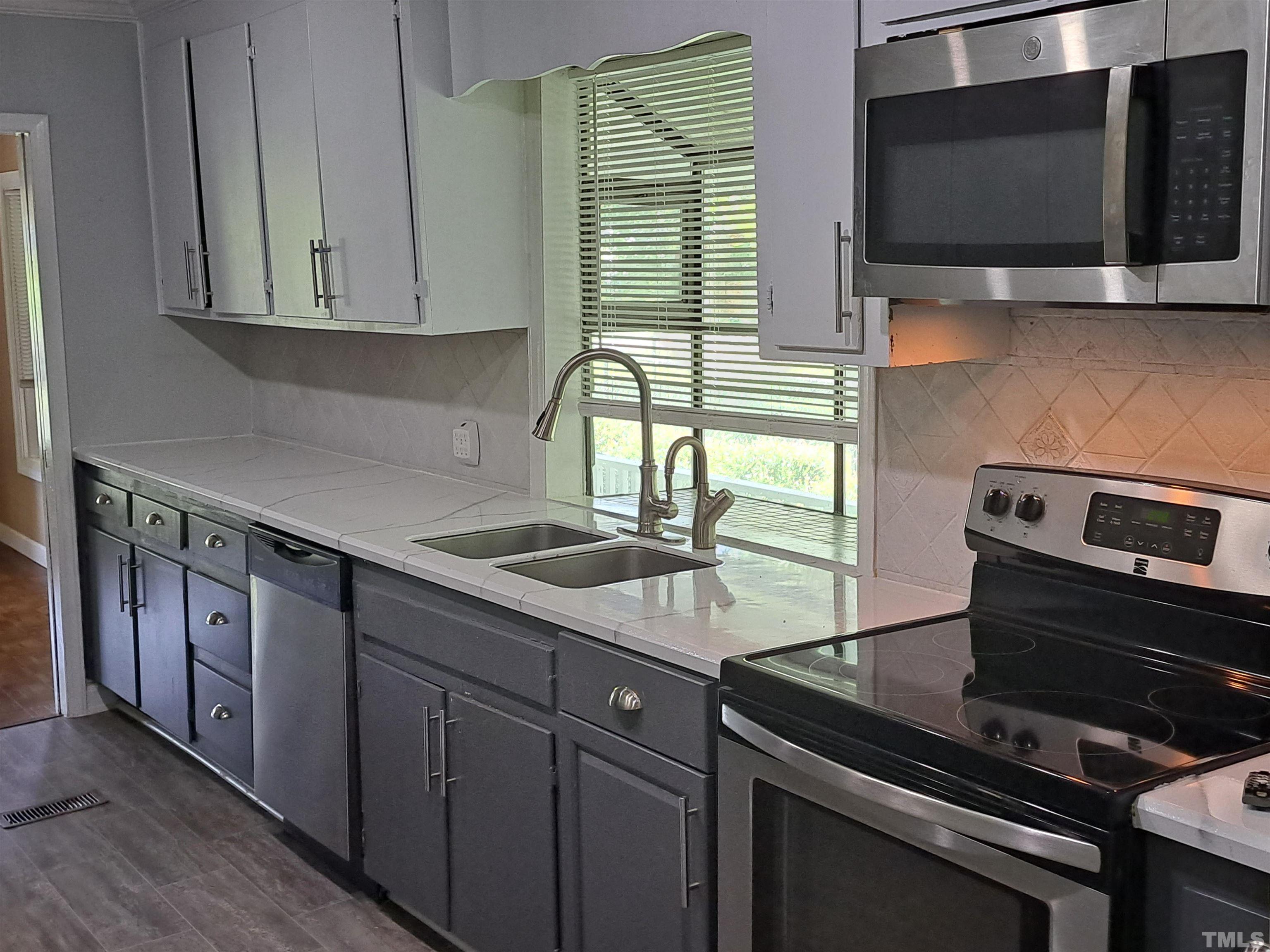 7313 Martin Road Zebulon, NC 27597 - Photo 3 of 19 a kitchen with a sink stove and microwave