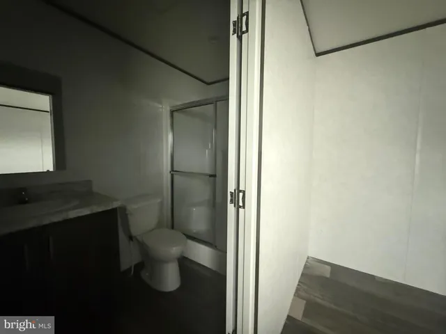 a bathroom with a granite countertop toilet and a sink