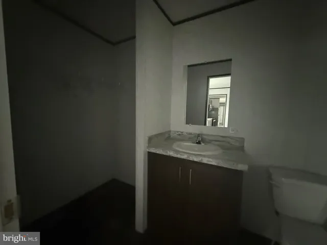 a bathroom with a granite countertop sink a toilet and mirror