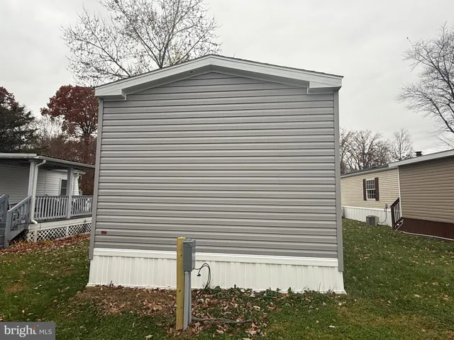 a white house with a small yard and a large tree