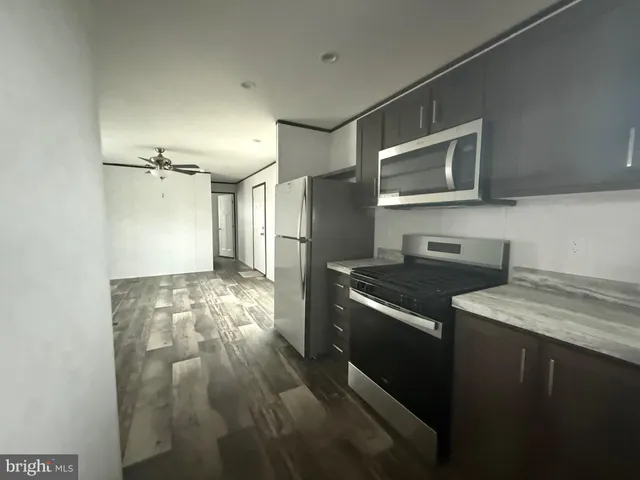 a kitchen that has a lot of cabinets and wooden floor