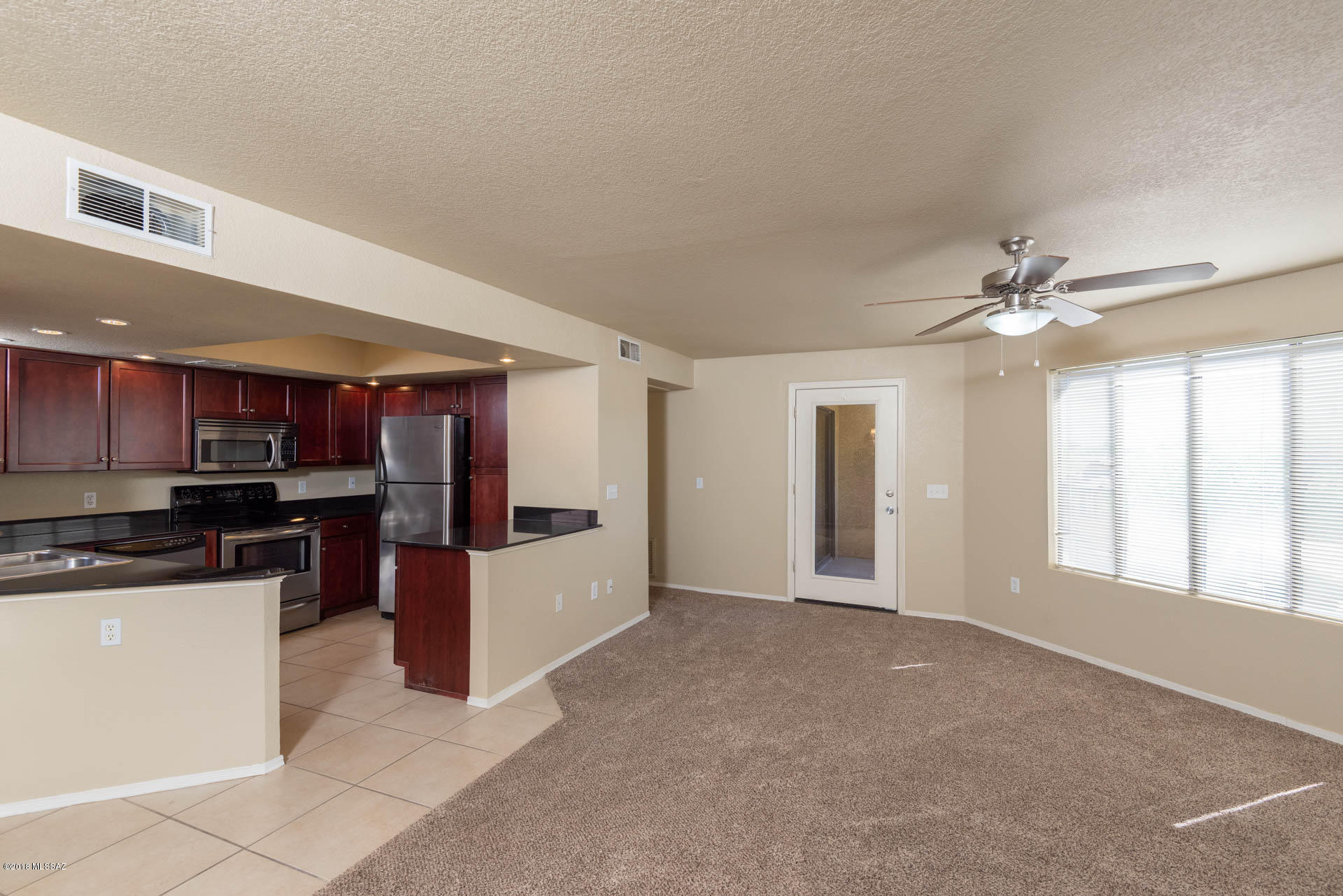 7255 East Snyder Road, Unit 8205 Tucson, AZ 85750 - Photo 1 of 23 a view of an empty room with kitchen view and a window