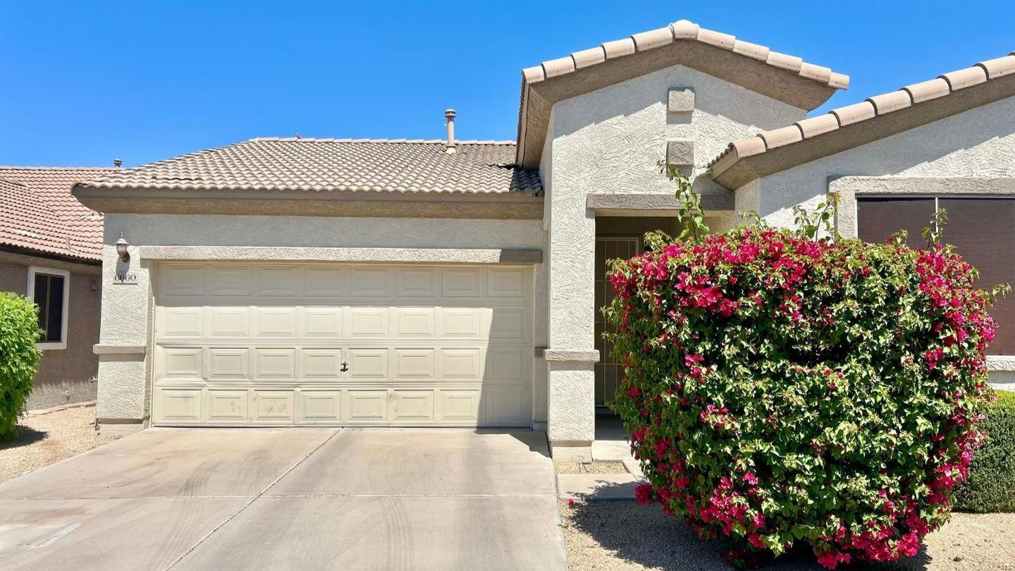 6660 East Roland Street Mesa, AZ 85215 - Photo 1 of 17 a front view of a house with a garage