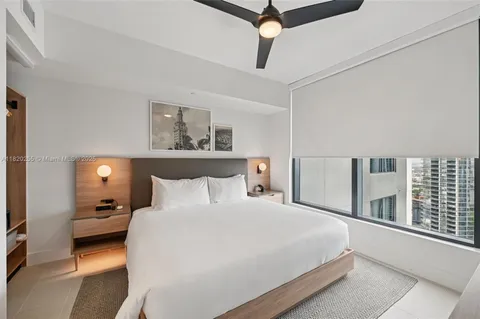 a bedroom with a bed and a large window