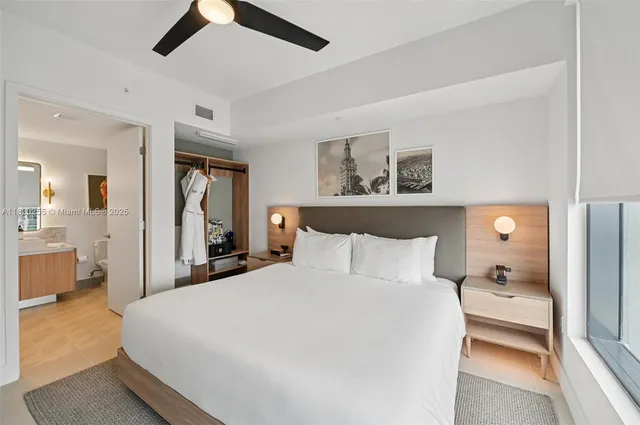 a bedroom with a large bed and a chandelier