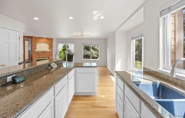 a large kitchen with kitchen island granite countertop a large window and a sink
