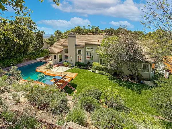 an aerial view of a house with a garden and lake view