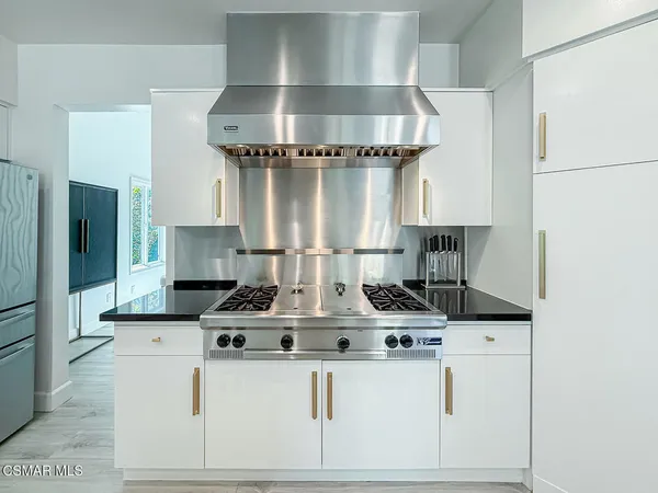 a kitchen with stainless steel appliances granite countertop a stove and a refrigerator