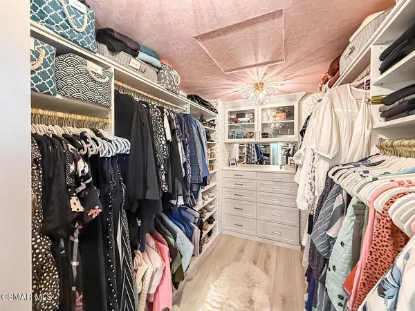 a view of walk in closet with clothes and shoes