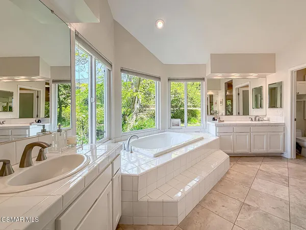a large bathroom with a large tub sink and window