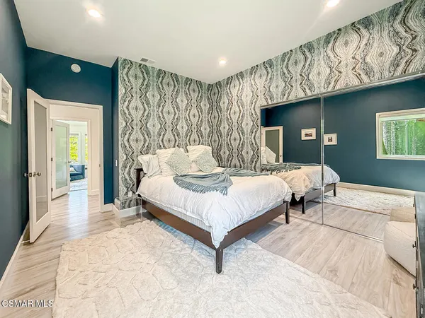 a bedroom with a bed lamp and a large window