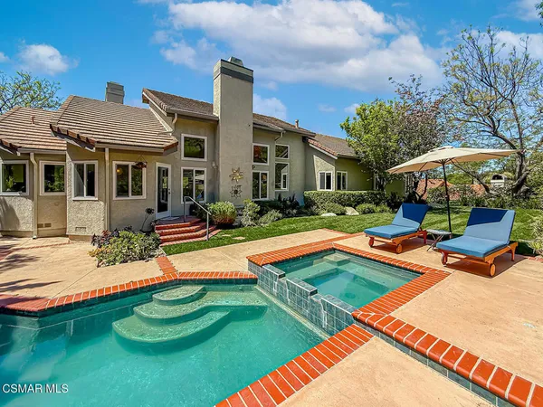 a view of a house with swimming pool and sitting area