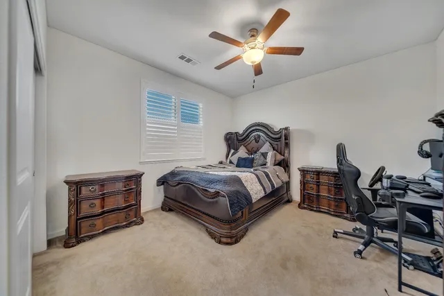 a bedroom with a bed and a ceiling fan
