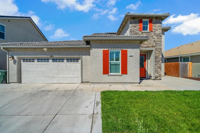 a front view of a house with a yard and garage