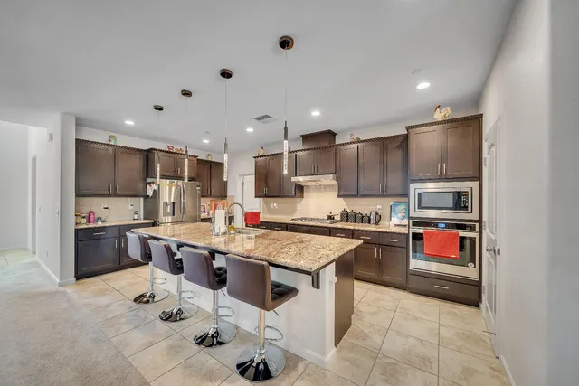 a kitchen with stainless steel appliances kitchen island granite countertop a sink and cabinets