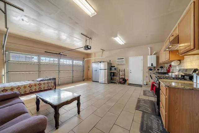 a open kitchen with granite countertop a stove and a view of living room