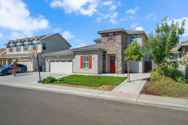 a front view of a house with a yard and garage