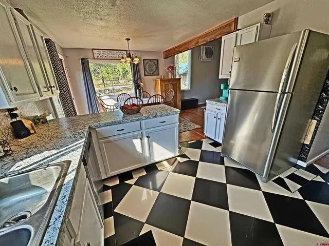 a kitchen with a refrigerator a sink and a mirror
