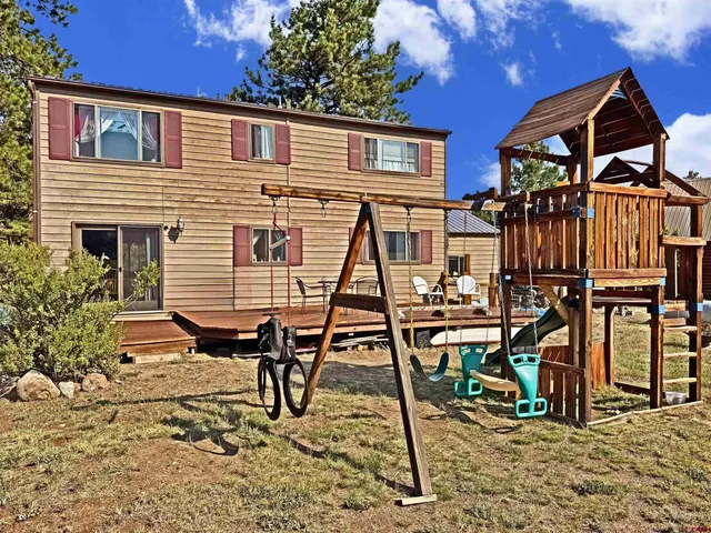 a view of a house with a wooden deck and furniture