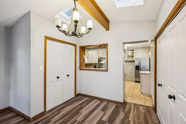a view of a hallway with wooden floor and a bathroom