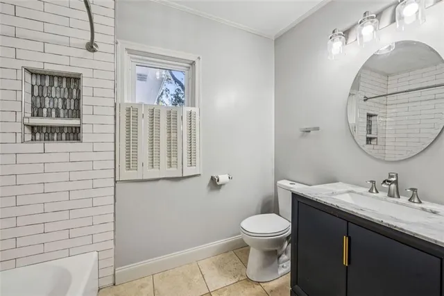 a bathroom with a granite countertop toilet a sink a mirror and a shower