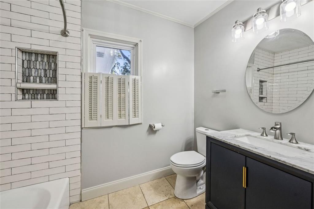 2050 Mercer Avenue Atlanta, GA 30337 - Photo 14 of 29 a bathroom with a granite countertop toilet a sink a mirror and a shower
