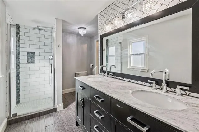 a bathroom with a granite countertop sink a mirror and shower