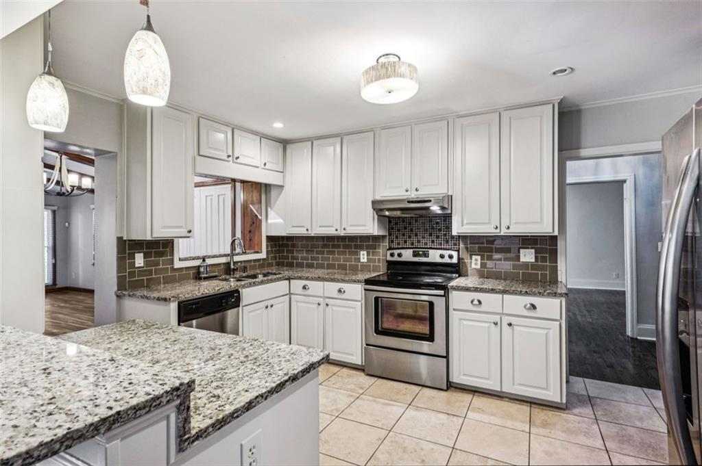 2050 Mercer Avenue Atlanta, GA 30337 - Photo 9 of 29 a kitchen with granite countertop stainless steel appliances cabinets a sink and a counter space