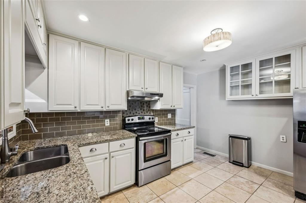 2050 Mercer Avenue Atlanta, GA 30337 - Photo 10 of 29 a kitchen with granite countertop a sink stainless steel appliances and cabinets