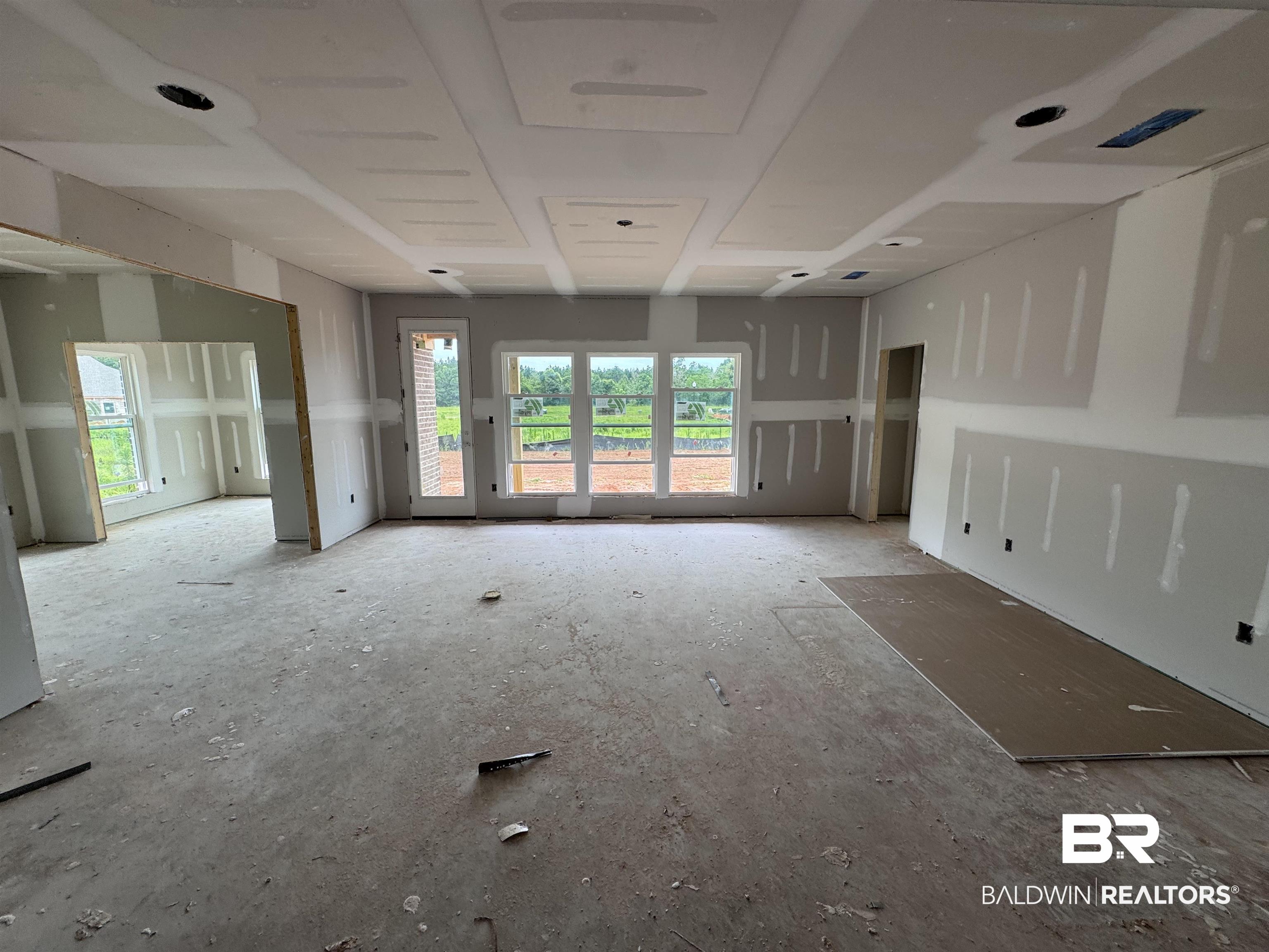 27355 Patch Pl Loop Daphne, AL 36526 - Photo 16 of 17 Expansive unfinished interior showcasing an open floor plan, multiple large windows, a glass-paned exterior door