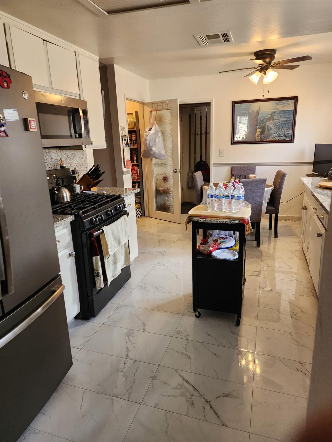 1406 Quail Street Los Banos, CA 93635 - Photo 8 of 18 a kitchen with stainless steel appliances a stove refrigerator and a microwave