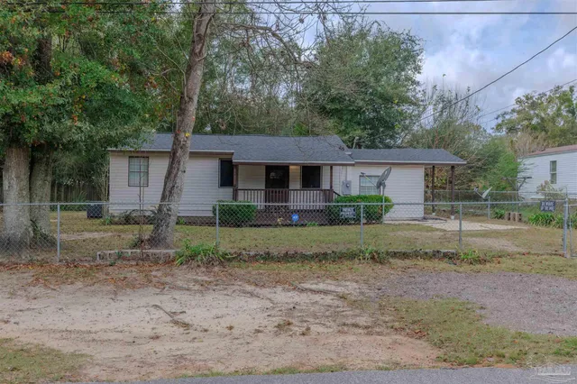 a view of a house with a yard and a large tree