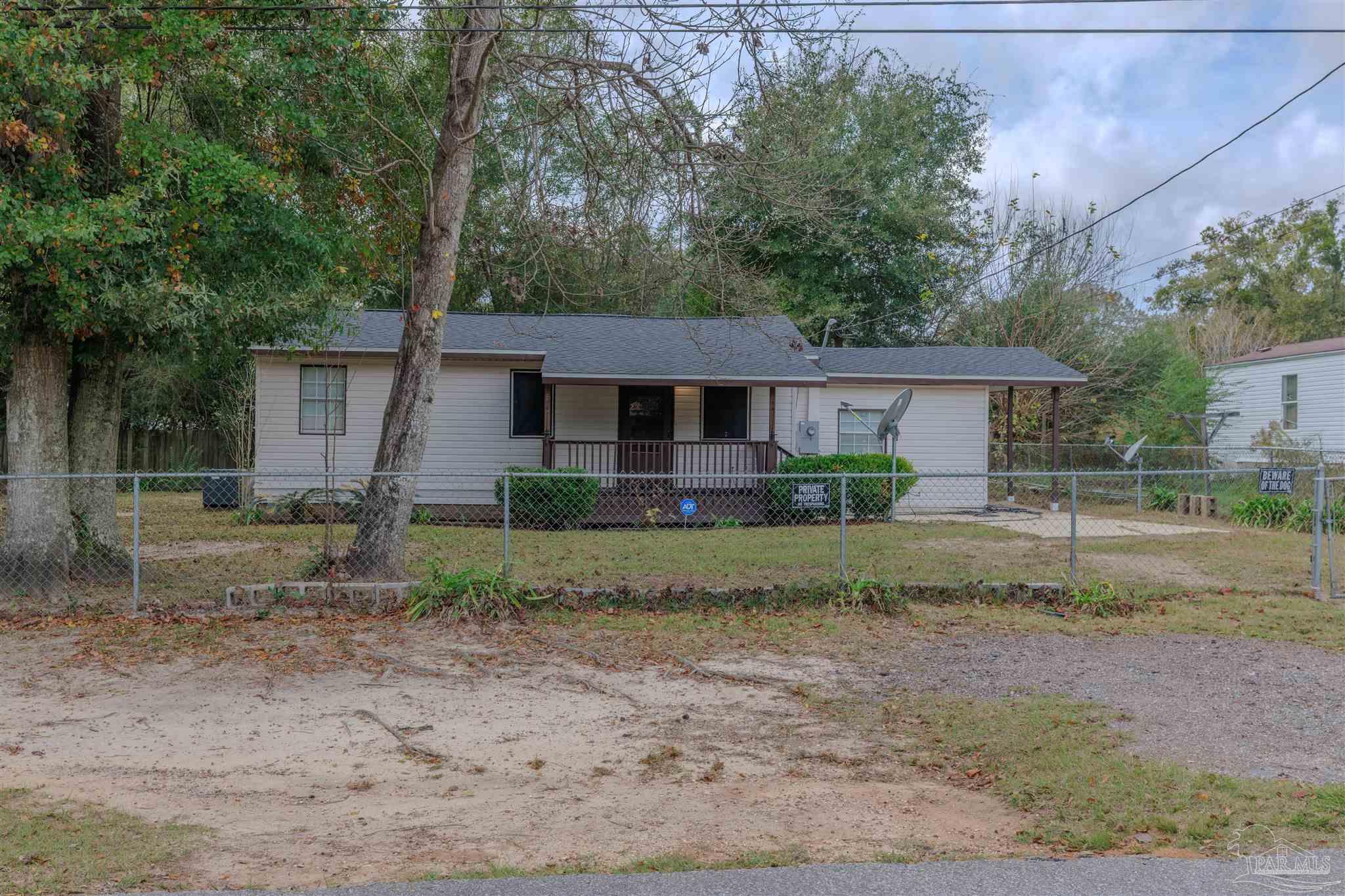 a view of a house with a yard and a large tree