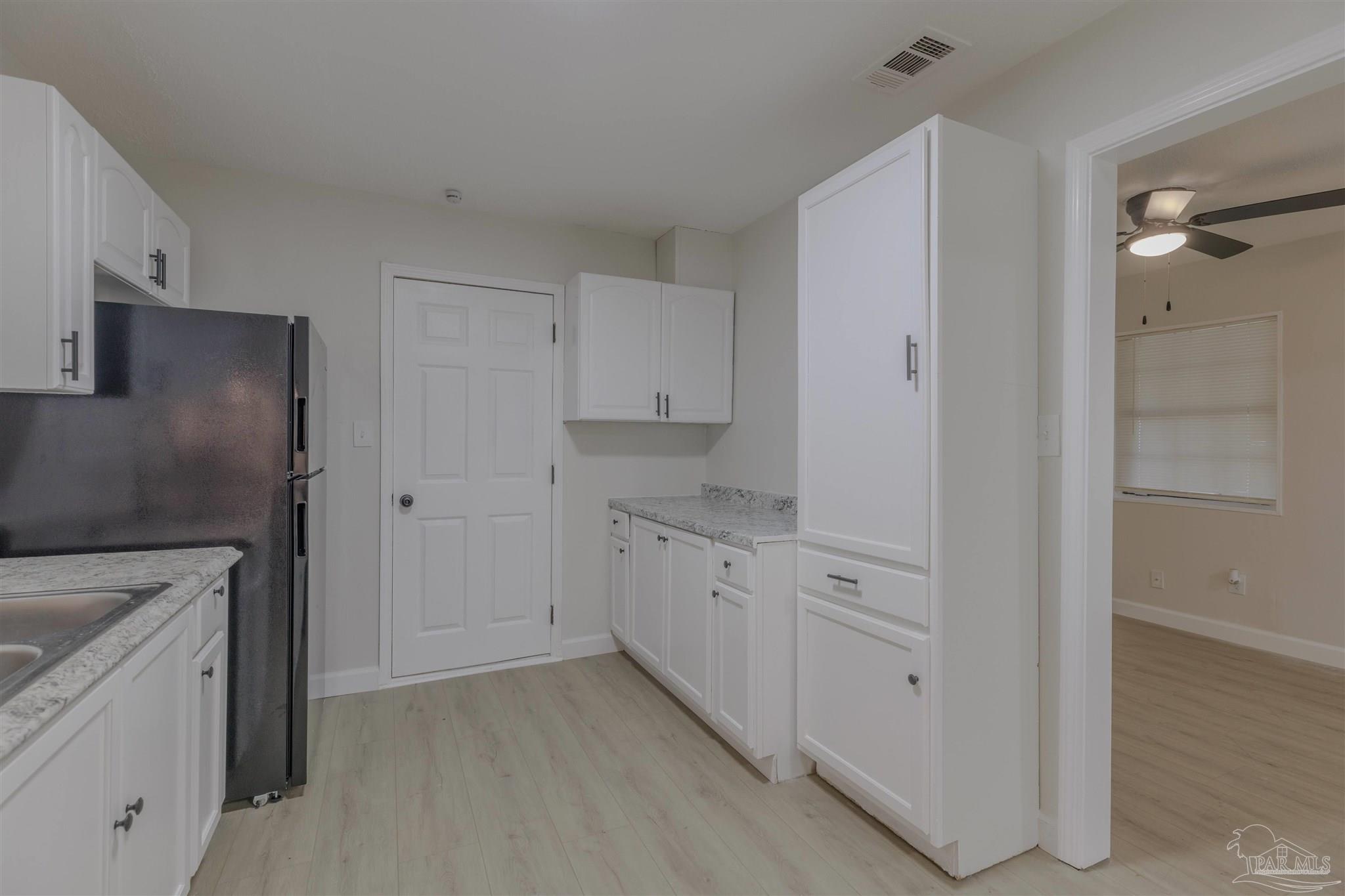 825 Booker Avenue Cantonment, FL 32533 - Photo 15 of 29 a kitchen with white cabinets and refrigerator